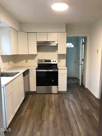 a kitchen with wooden floors and white appliances