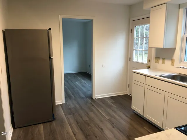 a kitchen with wooden floor and window