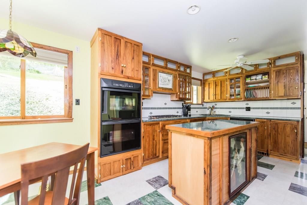 The spacious eat in kitchen has custom made wormy chestnut cabinetry & a double convection oven.