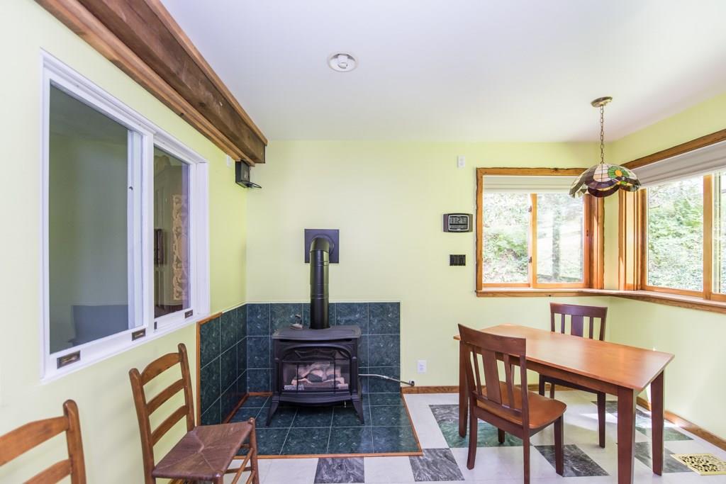 The eat in kitchen has one of 3 free standing Franklin stoves you will find in this home.
