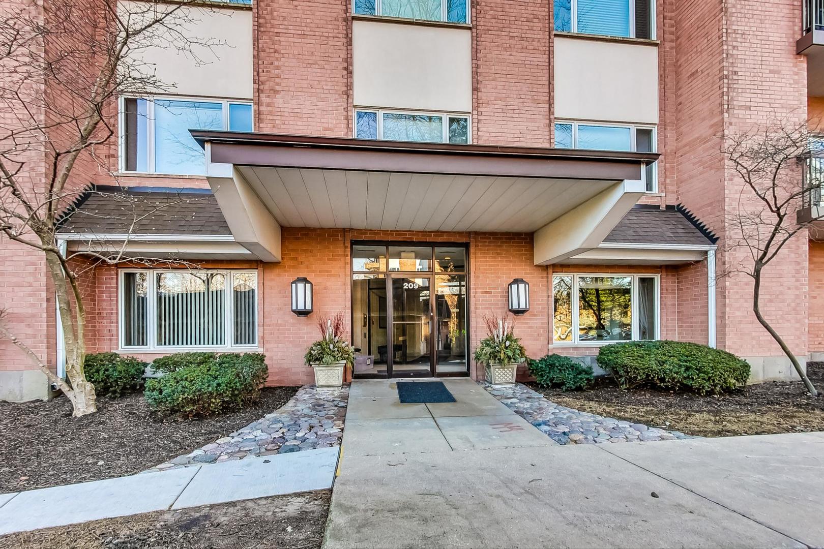 209 Rivershire Lane, Unit 503 Lincolnshire, IL 60069 - Photo 1 of 53 front view of a brick house with potted plants