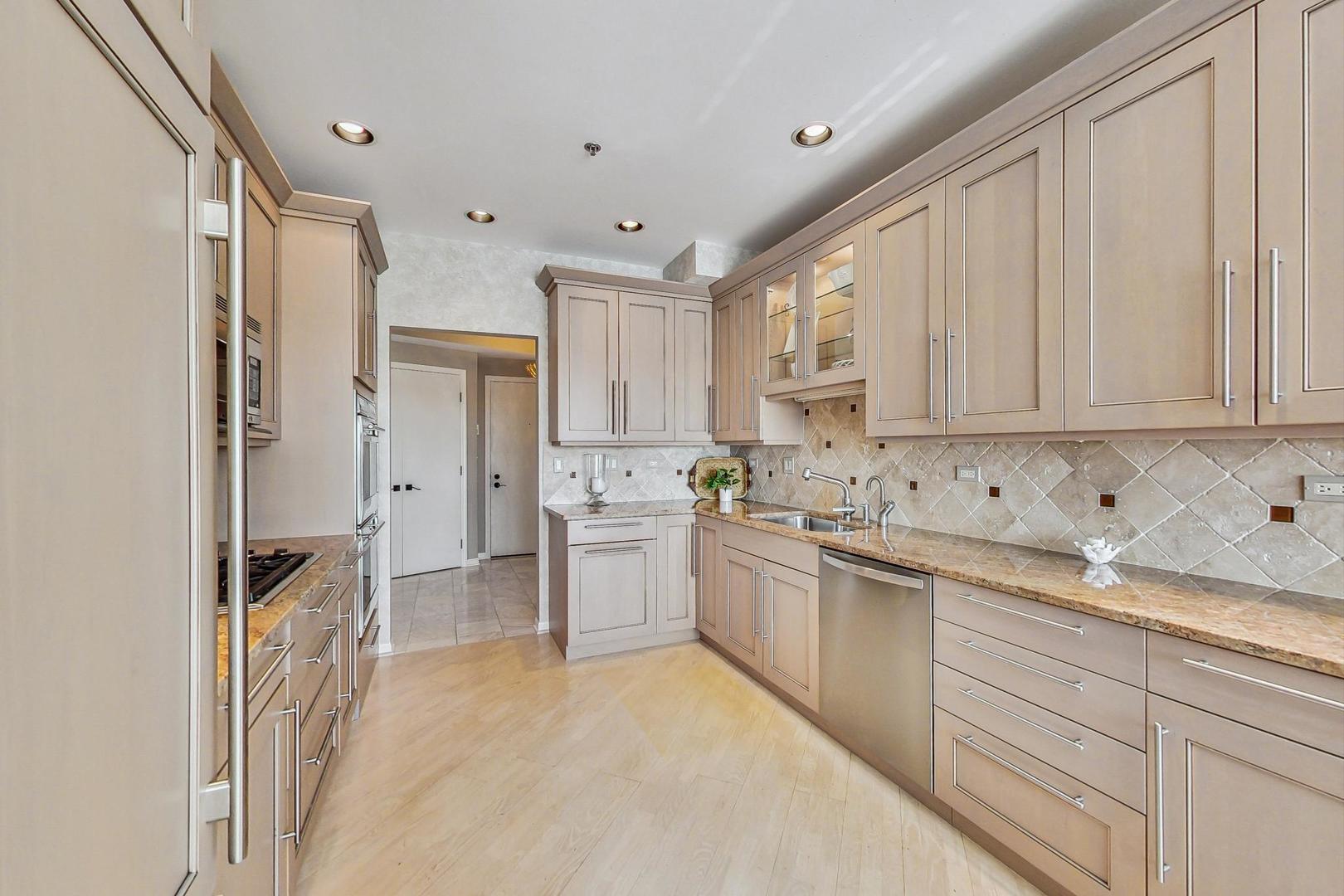 209 Rivershire Lane, Unit 503 Lincolnshire, IL 60069 - Photo 13 of 53 a kitchen with white cabinets and appliances