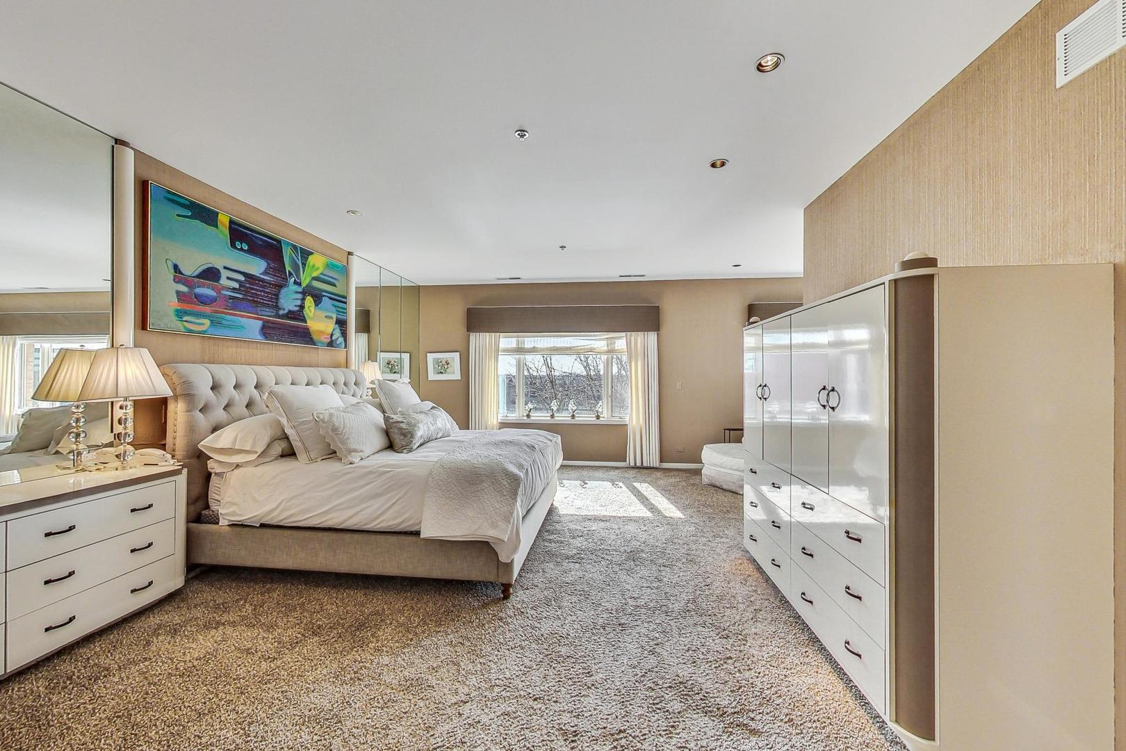 209 Rivershire Lane, Unit 503 Lincolnshire, IL 60069 - Photo 19 of 53 a spacious bedroom with a bed and a window