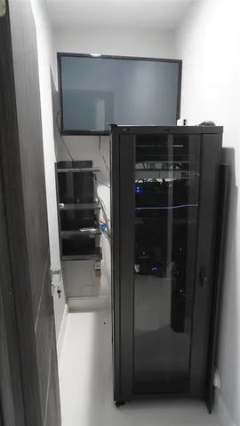 a living room with closet flat screen tv and a refrigerator