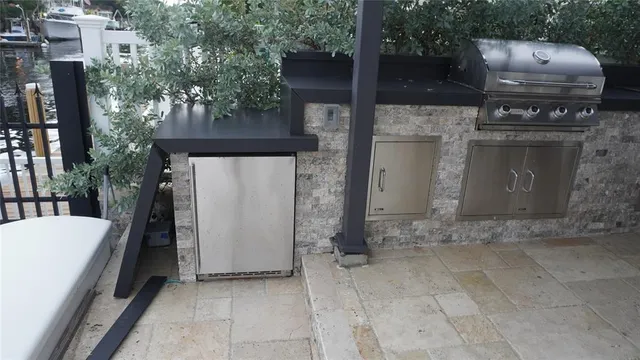 a kitchen with stainless steel appliances kitchen island granite countertop a table and chairs in it