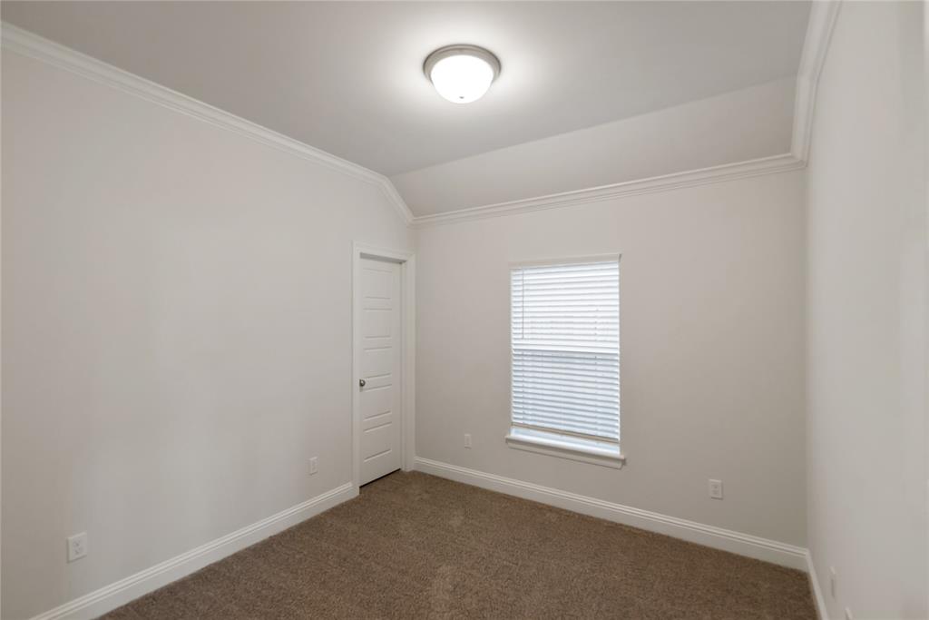 331 Prien Lk Loop Bossier City, LA 71111 - Photo 17 of 37 Spare room featuring ornamental molding, dark carpet, and vaulted ceiling