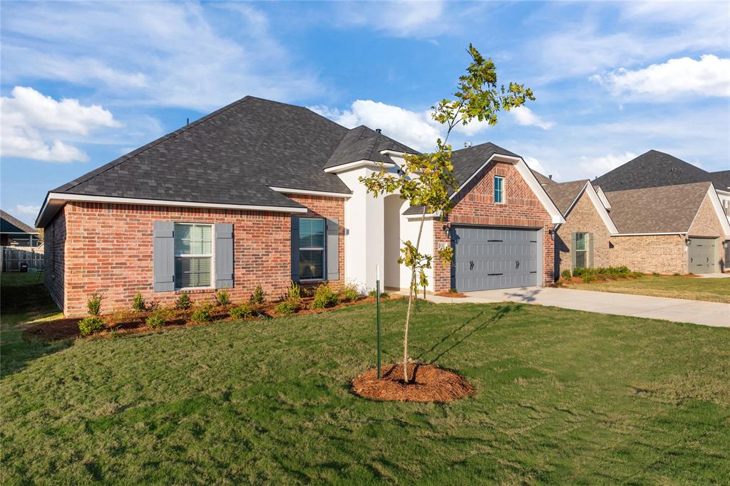 331 Prien Lk Loop Bossier City, LA 71111 - Photo 3 of 37 View of front of home featuring roof with shingles, driveway, a front yard, and brick siding