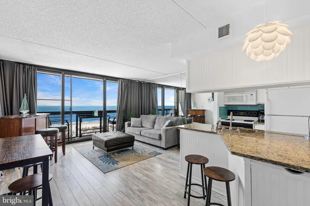 a living room with furniture a fireplace and large windows