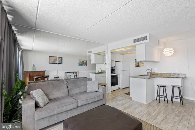 a living room with furniture and view of kitchen