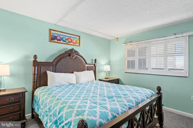 a bedroom with a bed and a dresser next to a window