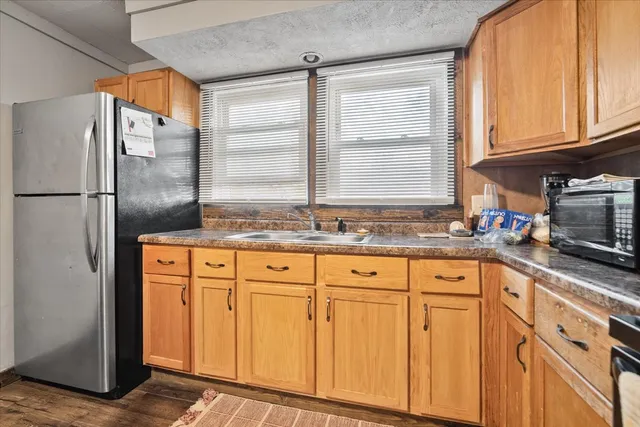 a kitchen with granite countertop cabinets stainless steel appliances a sink and a window