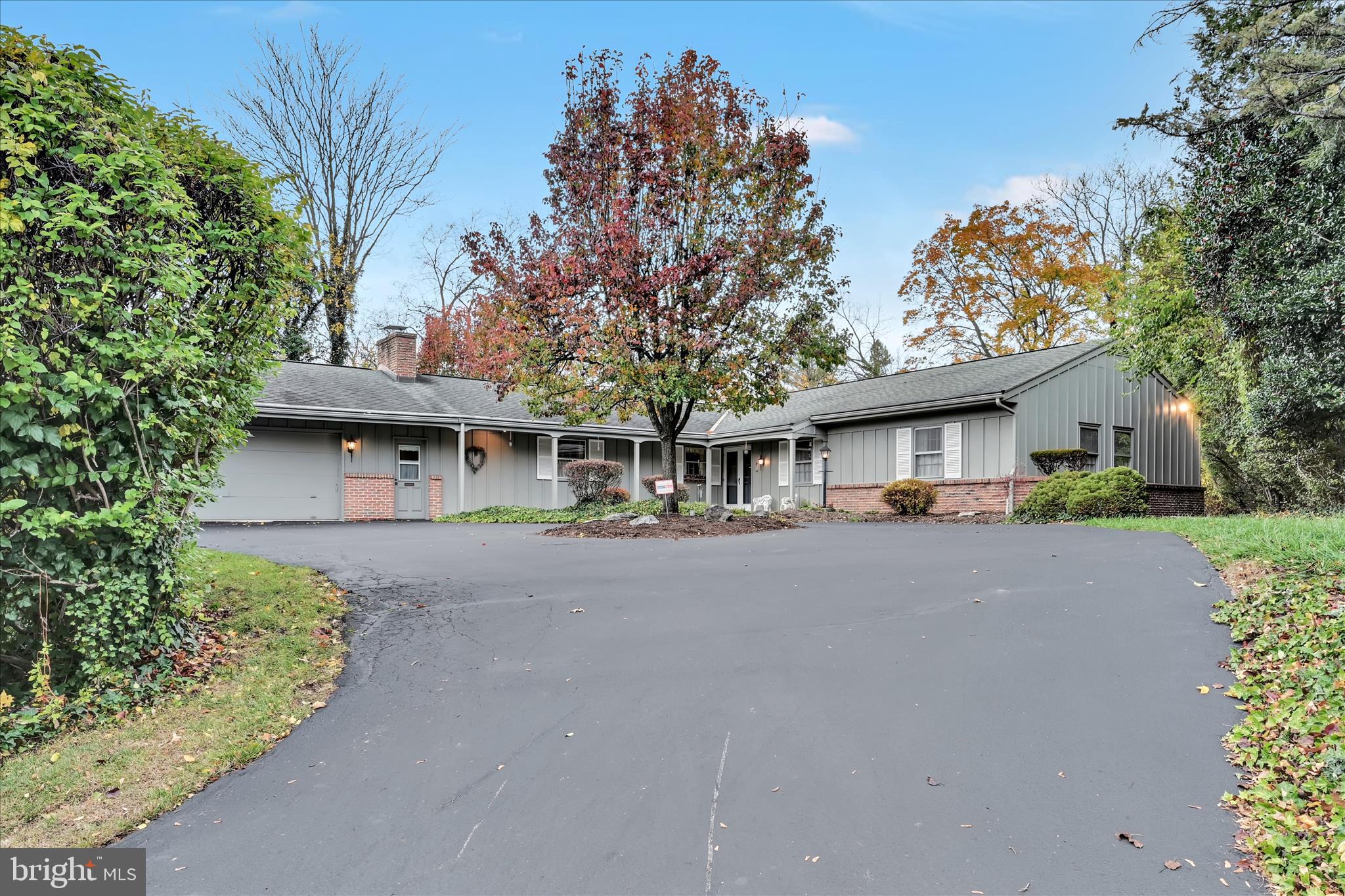 1451 Museum Road Wyomissing, PA 19610 - Photo 5 of 44 a front view of a house with a garden and trees