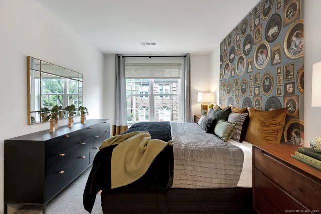a living room with furniture a lamp wooden floor and a large window
