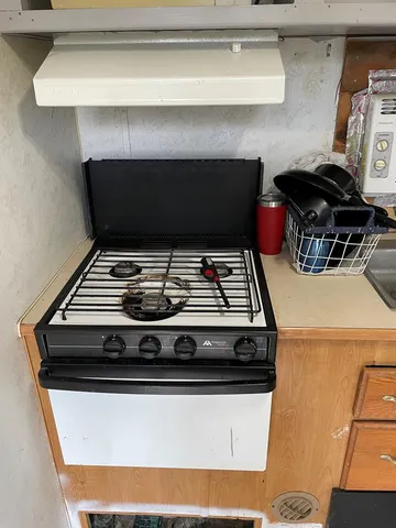 a stove top oven sitting inside of a kitchen