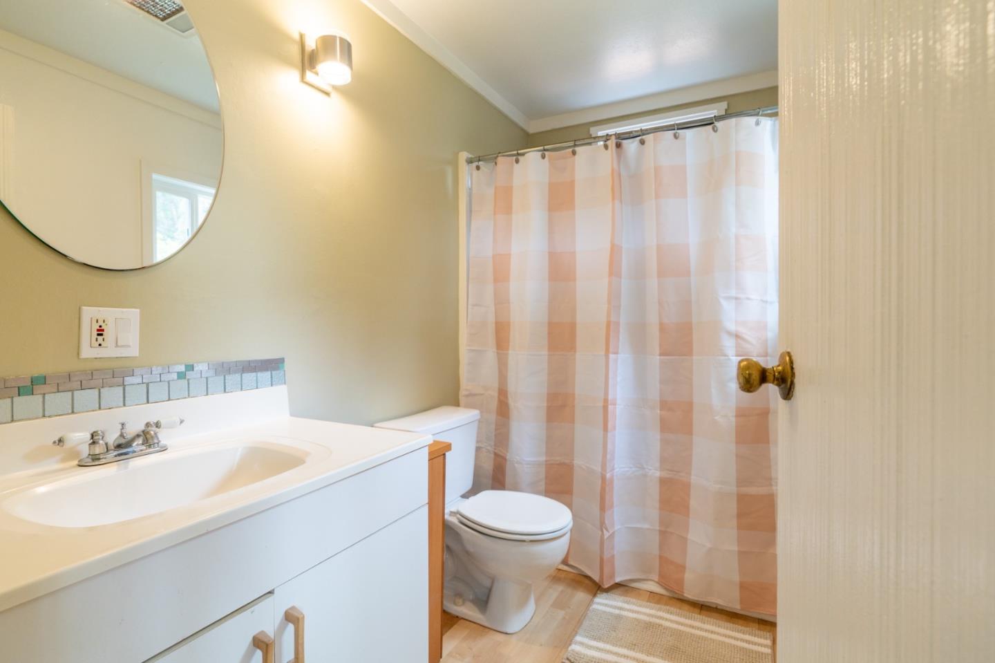424 Belfast Avenue Pacifica, CA 94044 - Photo 10 of 11 a bathroom with a sink a toilet and shower curtain