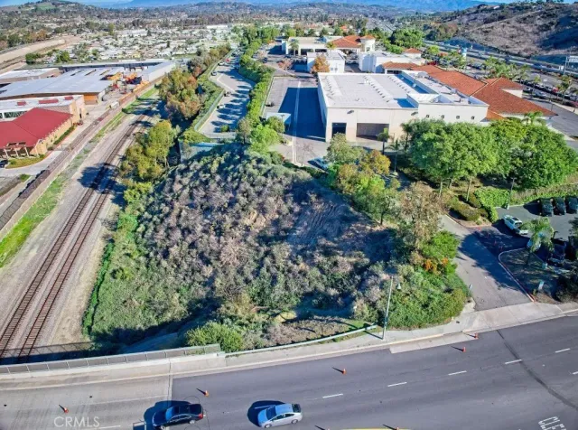 an aerial view of residential houses with outdoor space and street view