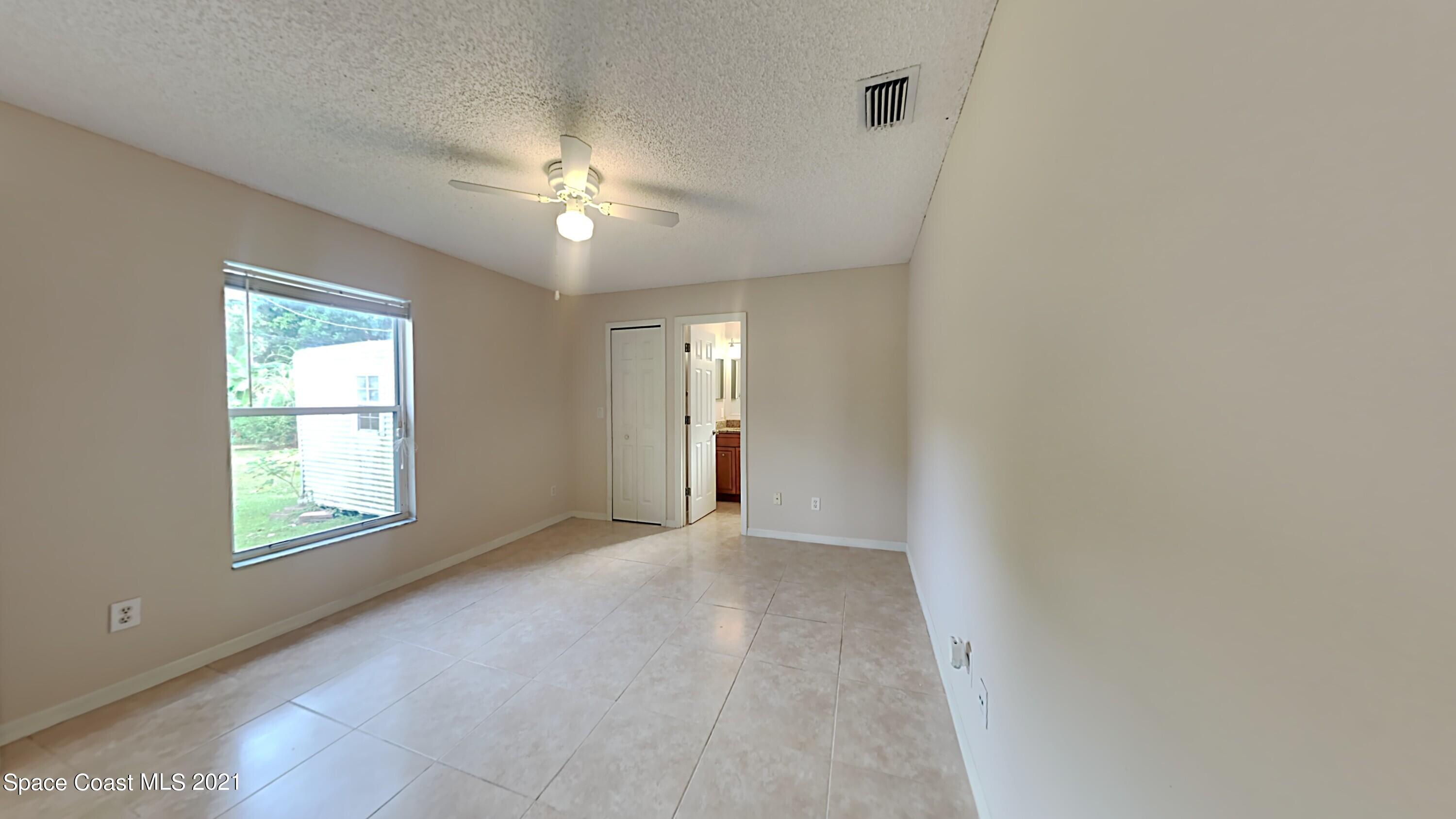 1327 Whitehurst Road Southwest Palm Bay, FL 32908 - Photo 12 of 21 an empty room with windows and fan
