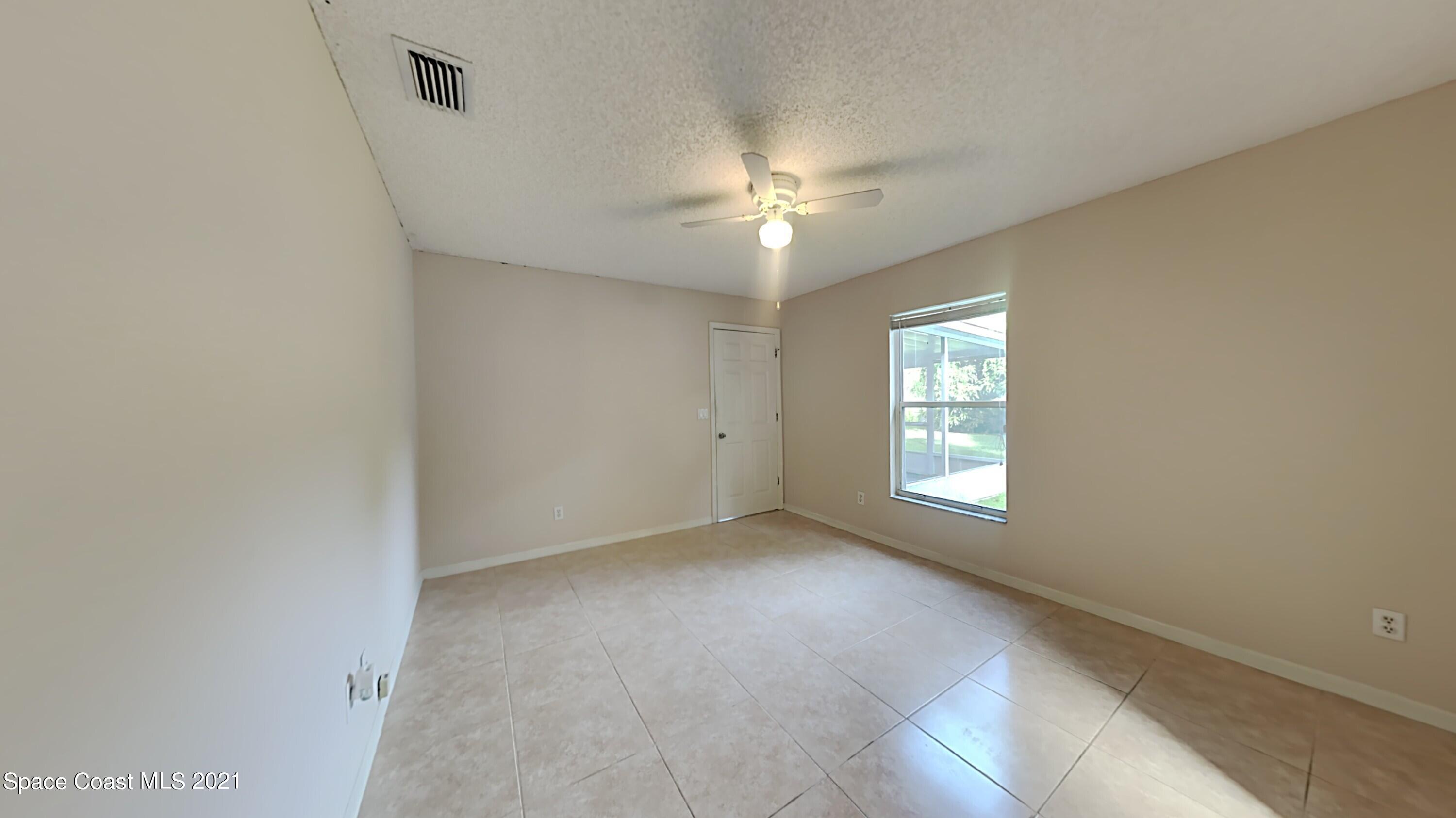 1327 Whitehurst Road Southwest Palm Bay, FL 32908 - Photo 13 of 21 an empty room with a window and a fan