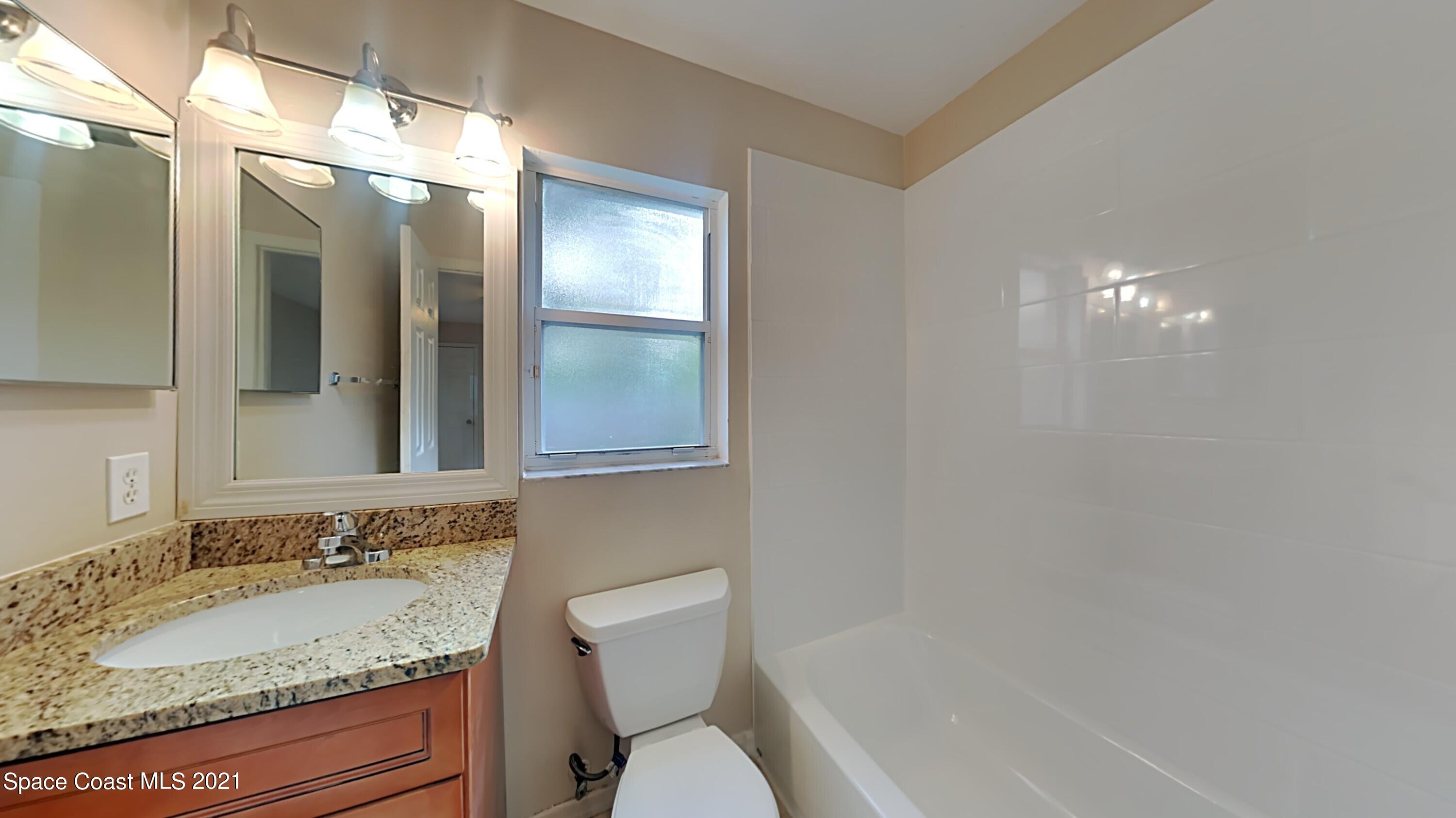 1327 Whitehurst Road Southwest Palm Bay, FL 32908 - Photo 14 of 21 a bathroom with a granite countertop sink and a mirror