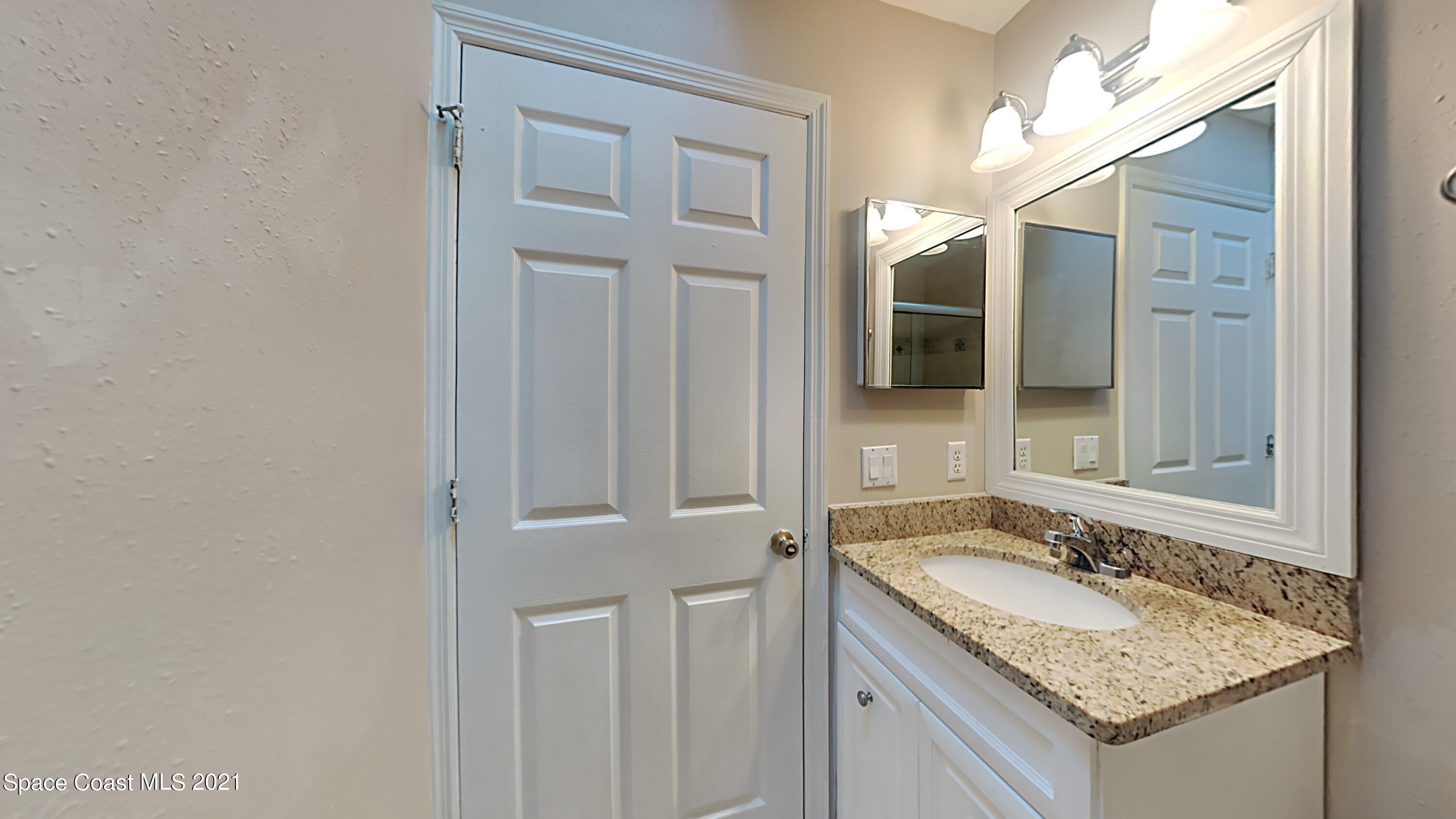 1327 Whitehurst Road Southwest Palm Bay, FL 32908 - Photo 19 of 21 a bathroom with a granite countertop sink and a mirror