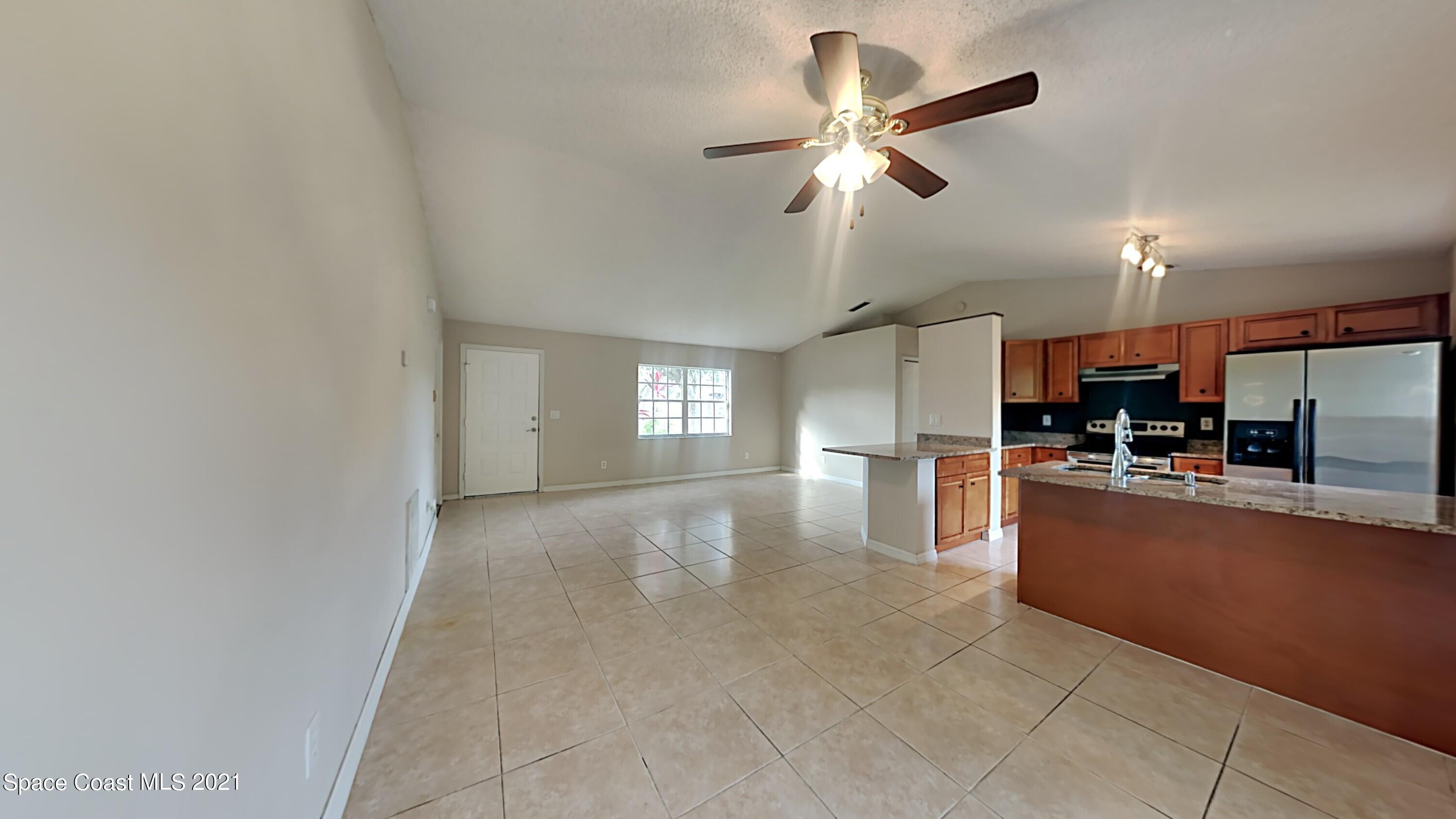 1327 Whitehurst Road Southwest Palm Bay, FL 32908 - Photo 3 of 21 a view of a kitchen with furniture and a ceiling fan