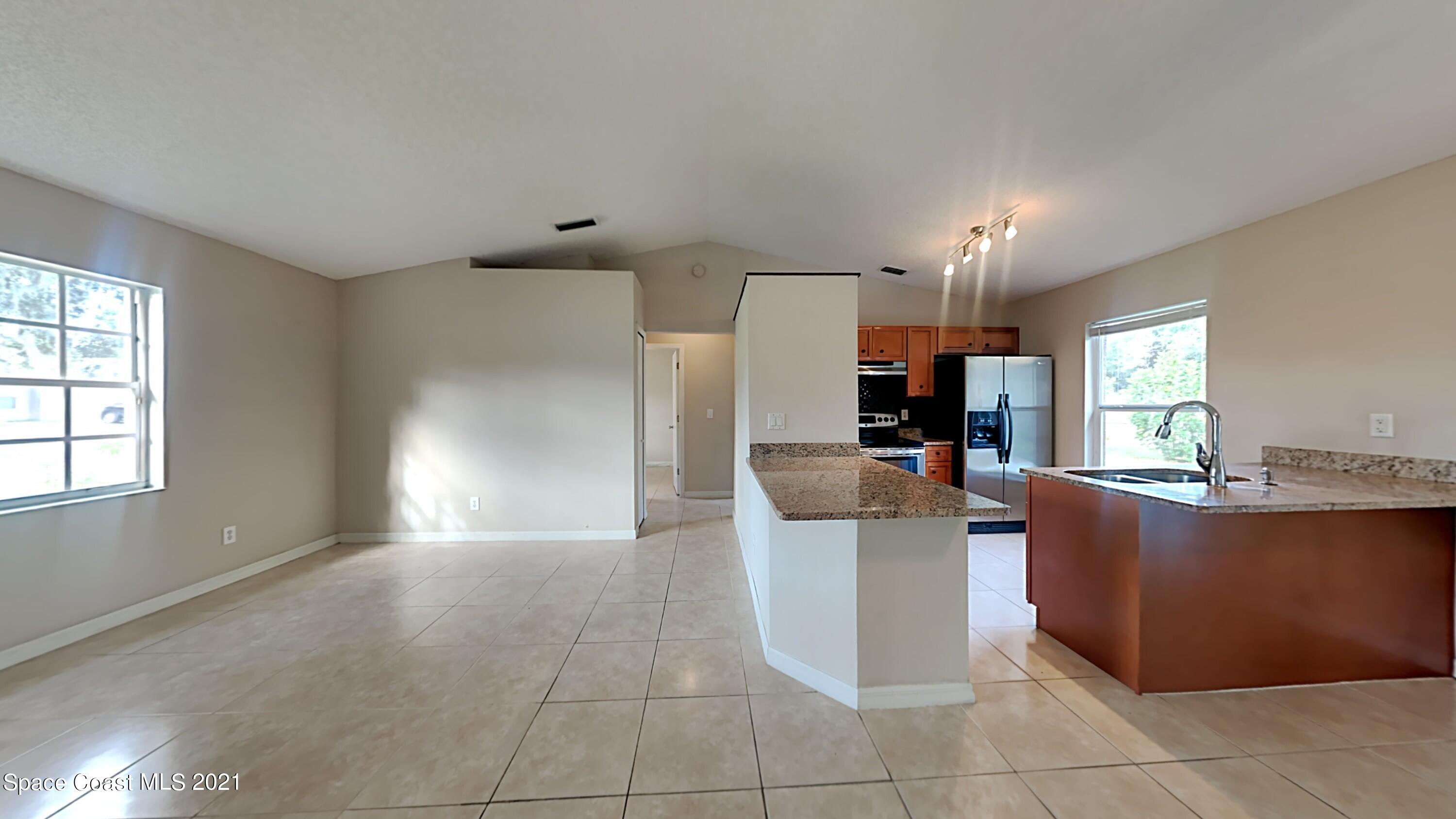 1327 Whitehurst Road Southwest Palm Bay, FL 32908 - Photo 4 of 21 a living room with furniture and a open kitchen