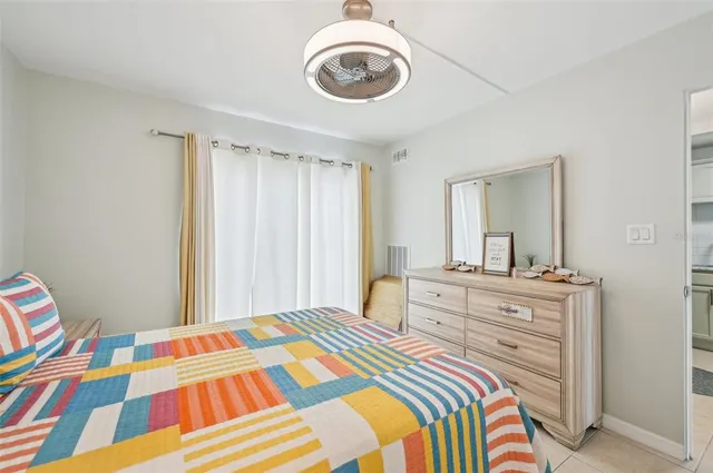 a bedroom with a bed and a mirror on dresser