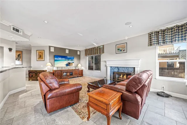 a living room with furniture a fireplace and a large window