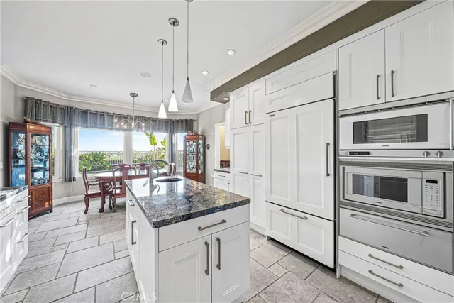 a kitchen with granite countertop a stove cabinets and refrigerator