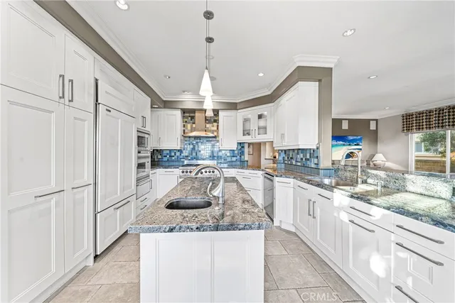 a kitchen with stainless steel appliances granite countertop a sink refrigerator and cabinets