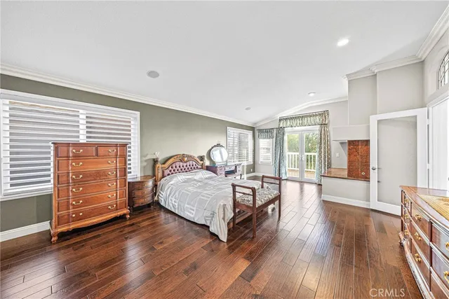 a spacious bedroom with a bed and wooden floor
