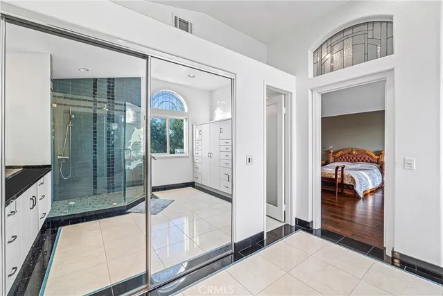 a bathroom with a granite countertop sink a mirror a glass door and shower