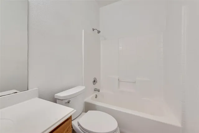a white toilet and tub sitting next to a bathroom sink