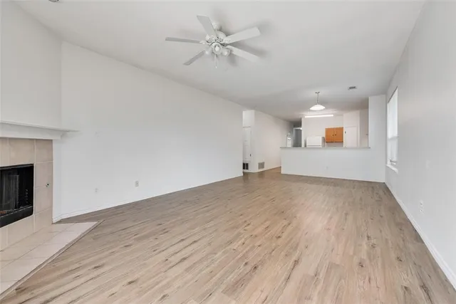 an empty room with wooden floor and a ceiling fan