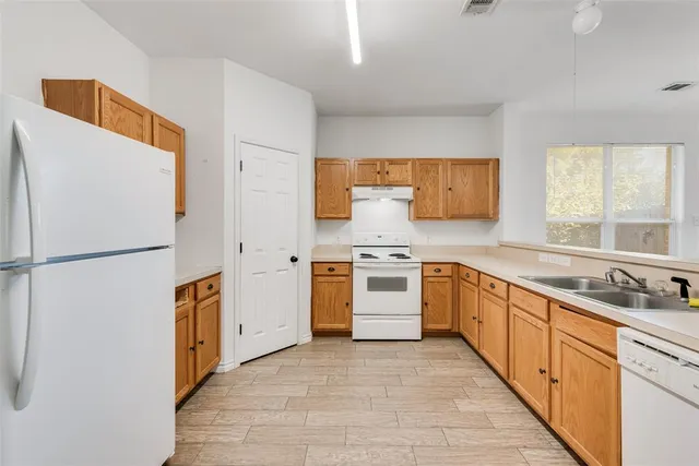 a kitchen with white cabinets and white appliances