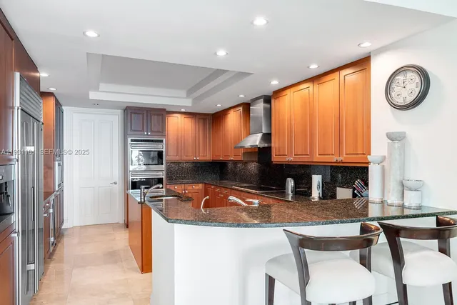 a kitchen with stainless steel appliances granite countertop a sink refrigerator stove and microwave