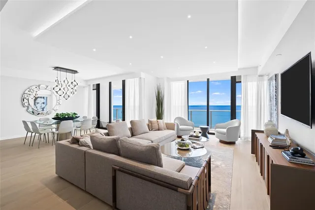 a living room with furniture flat screen tv and a large window