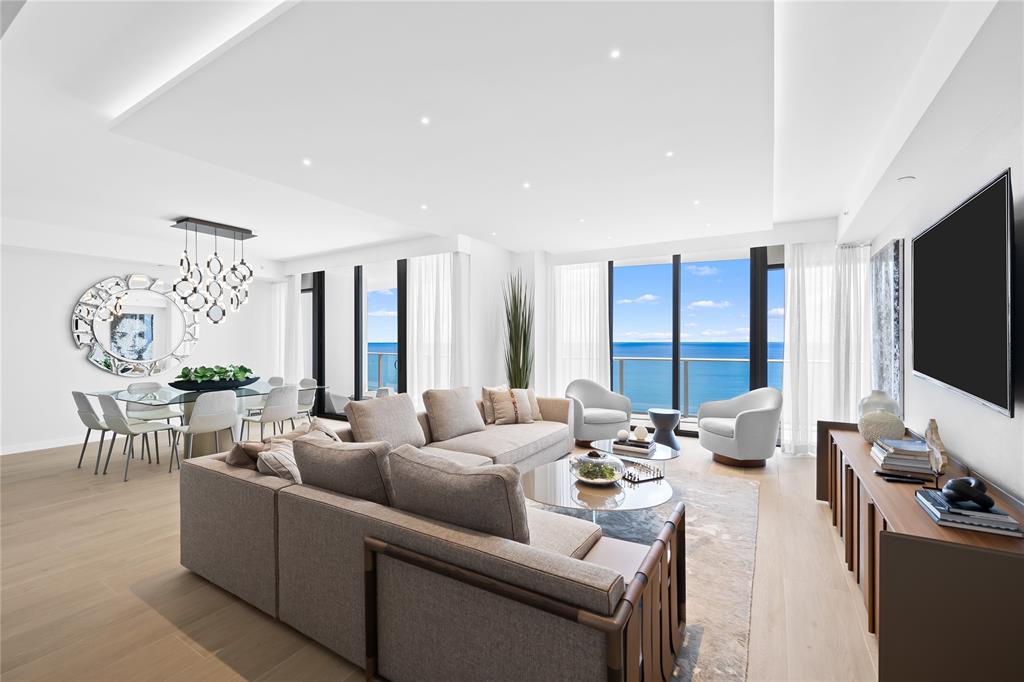 a living room with furniture flat screen tv and a large window