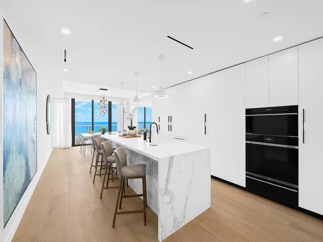 a spacious bedroom with a bed a couch and potted plant on the dresser