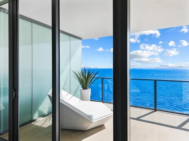 a living room with furniture and a large window with wooden floor