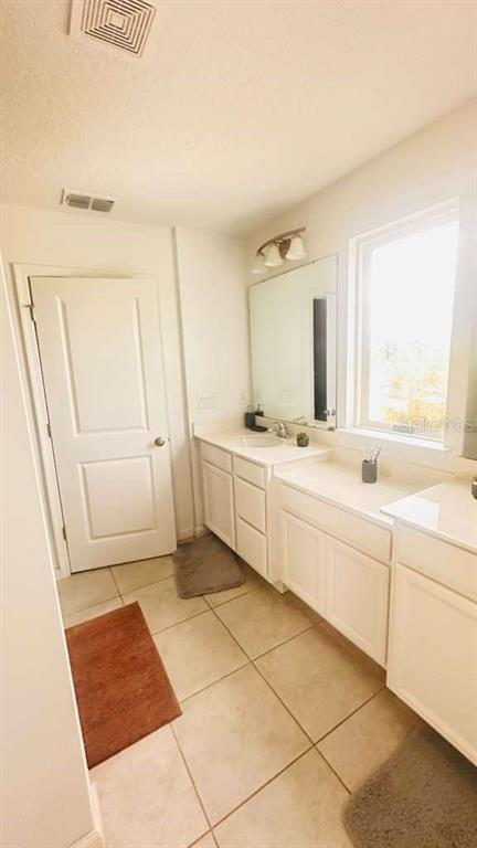 3166 Armstrong Spring Drive Kissimmee, FL 34744 - Photo 26 of 30 a bathroom with a sink a mirror and a bathtub