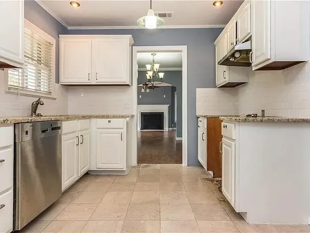 a kitchen with white cabinets and sink