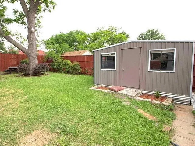 a backyard of a house with table and chairs