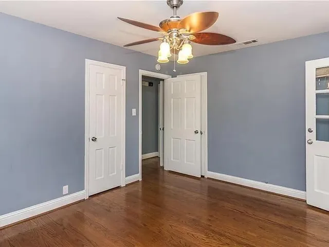 a view of an empty room with wooden floor