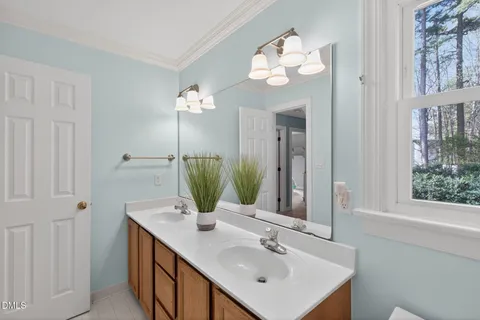 a bathroom with a double vanity sink mirror and toilet