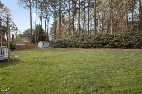 a front view of a house with a garden and trees