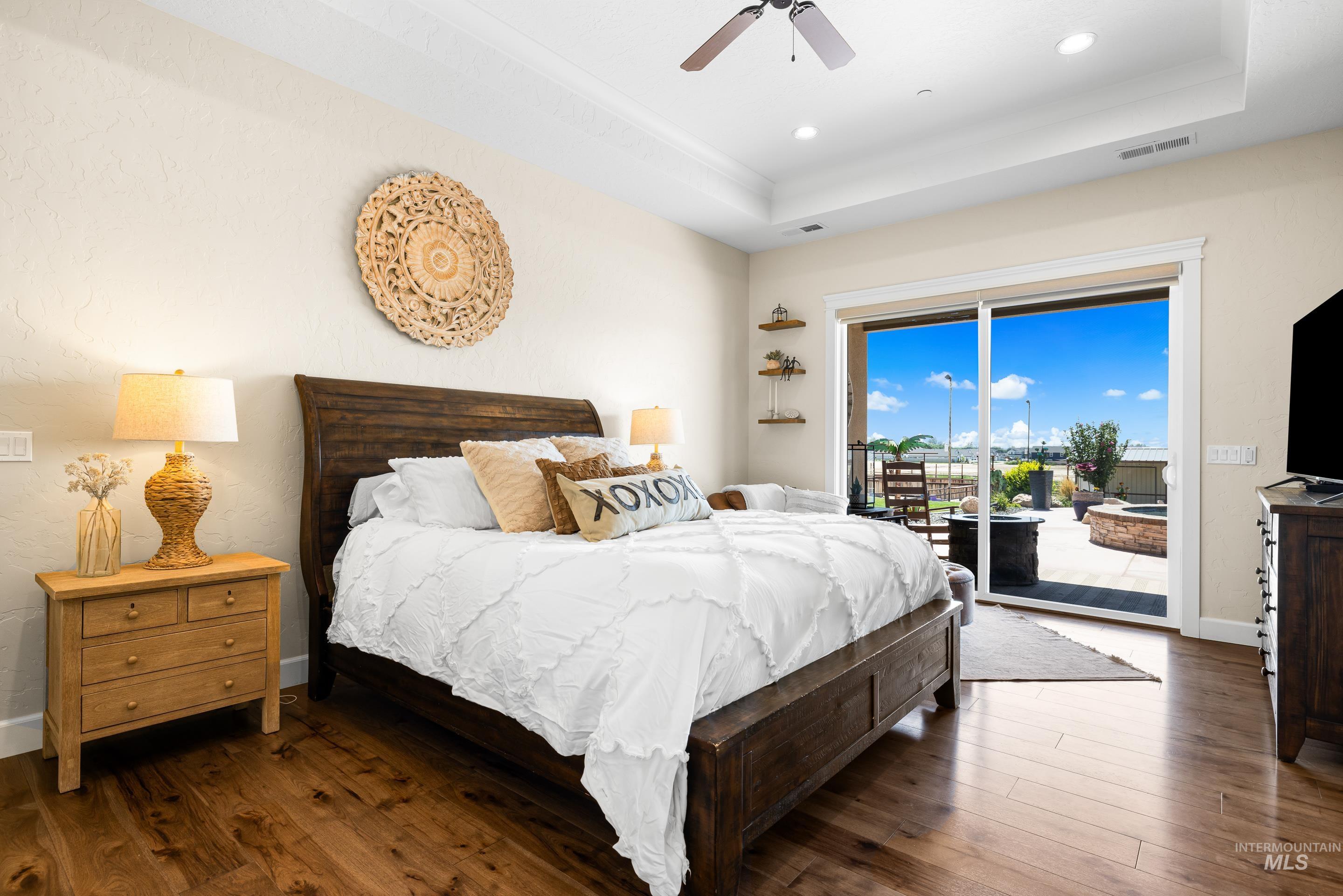 9819 Foothill Road Middleton, ID 83644 - Photo 24 of 49 Bedroom featuring access to exterior, wood finished floors, a raised ceiling, a ceiling fan, and recessed lighting