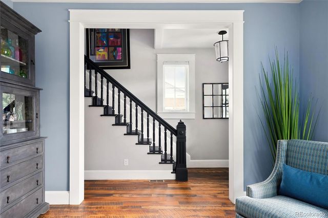 a view of a livingroom with wooden floor and staircase