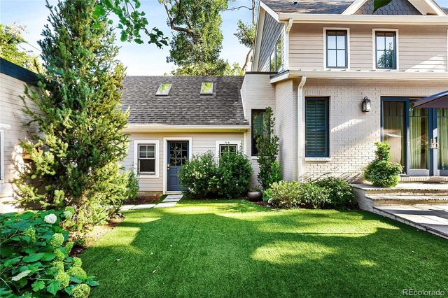 a front view of a house with a yard and trees