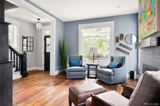 a living room with furniture a fireplace and a large window